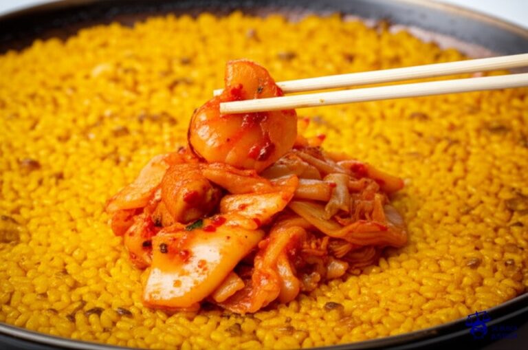 Un plato de paella (España) intentando desesperadamente atrapar con palillos un puñado de kimchi (Corea del Sur) que se mueve y salta por todo el plato. Representa: España vs Corea del Sur