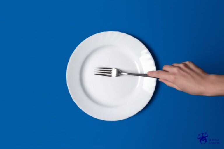 Un plato de comida vacío con un tenedor clavado en el centro, y alrededor del plato, una mano que se aleja rápidamente. Representa: Negativa a pagar alimentos por hijo con discapacidad