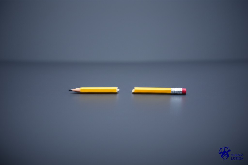 Un escritorio vacío, con un solo lápiz roto en el centro. Representa: No provisión de elementos de trabajo