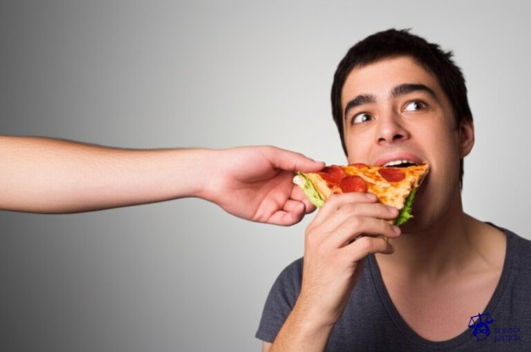 Una mano que intenta meter una pizza entera en la boca de una persona que ya está comiendo un sándwich. Representa: Ofrecimiento de productos no solicitados