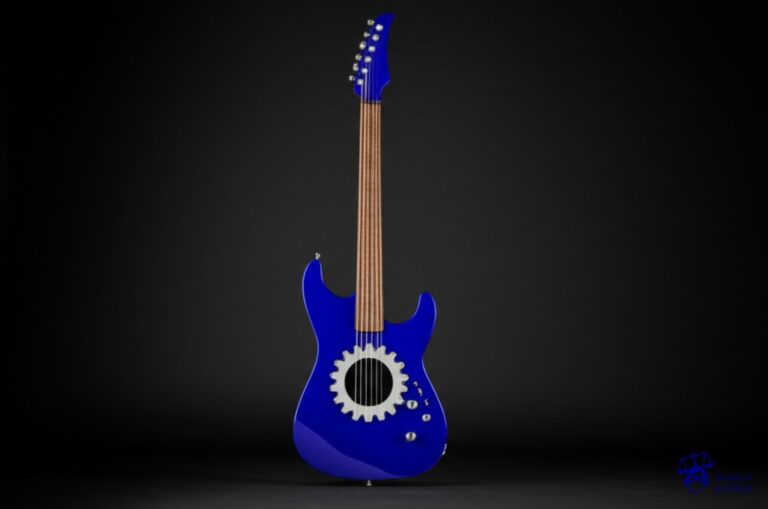 Una guitarra eléctrica, con un gran agujero en forma de engranaje atravesándola. Representa: Pappo sufrio el embate de la maquinaria represiva del estado durante la dictadura argentina