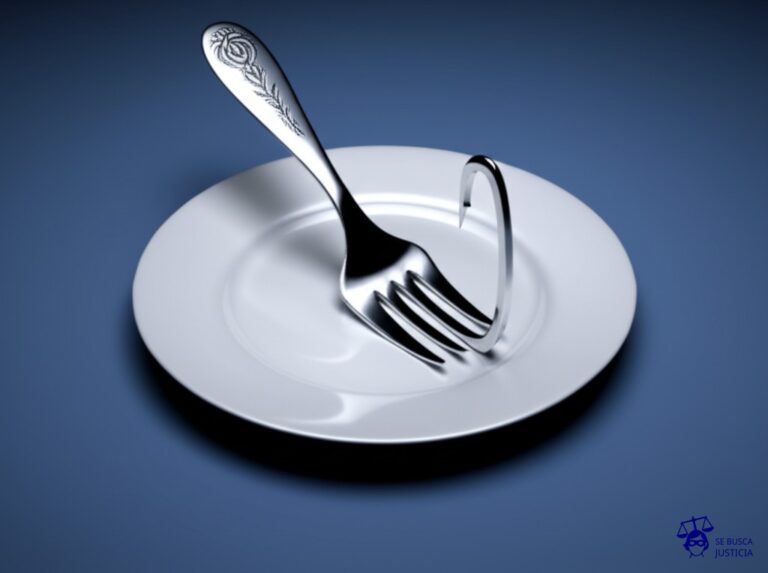 Un anzuelo gigante, desproporcionadamente grande, con forma de tenedor de mesa, clavado en un plato hondo vacío. Representa: Pesca ilegal en zonas vedadas o sobreexplotadas