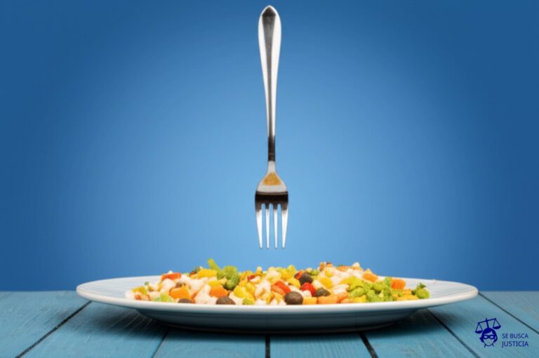 Un plato de comida a medio comer, con un tenedor clavado en el aire, suspendido sobre la mesa. Representa: Suspensión sin causa ni pago