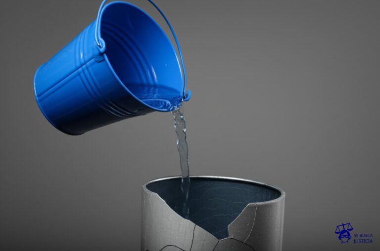 Un balde lleno de agua (representando el trabajo del empleado) goteando constantemente en un recipiente roto (representando el salario que no cubre lo mínimo). Representa: El no pago del salario mínimo vital y móvil, o el pago de una remuneración por debajo de la establecida por el convenio colectivo de trabajo, a pesar de que el trabajador cumple con sus tareas de manera habitual, lo que genera una deuda salarial acumulada y la posibilidad de iniciar un reclamo por diferencias de haberes.