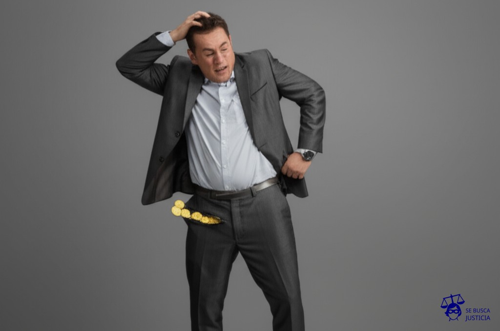 Un hombre con un agujero gigante en el bolsillo, intentando desesperadamente meter monedas en él. Representa: La falta de pago del subsidio por desempleo, a pesar de que el trabajador cumple con los requisitos para acceder a esta prestación, lo que genera un perjuicio económico para el empleado y lo obliga a iniciar un reclamo para obtener el pago de la misma.